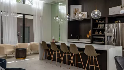 A sophisticated communal kitchen with a large island, stylish barstools, and modern pendant lighting, creating an inviting social space.