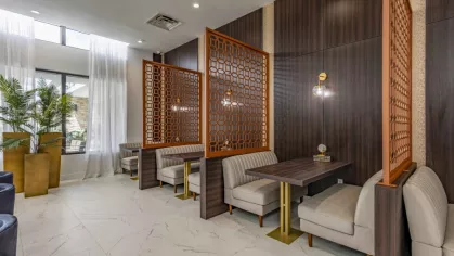 An intimate clubhouse setting with cozy booths, intricate wooden partitions, and modern lighting, ideal for relaxation and socialization.