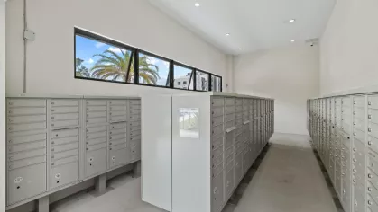 A bright and spacious mailroom with organized mailboxes, large windows, and a streamlined design for residents’ convenience.