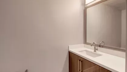 Clean and elegant bathroom design with a large mirror and modern vanity at The Pacific Luxury Apartments.