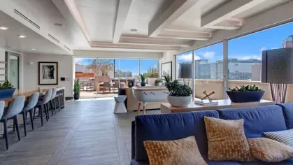 Bright and open social lounge with contemporary furnishings and access to an outdoor terrace.