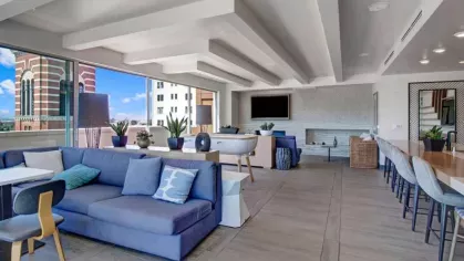 Versatile community lounge with plush seating, dining space, and large windows at The Pacific Luxury Apartments.