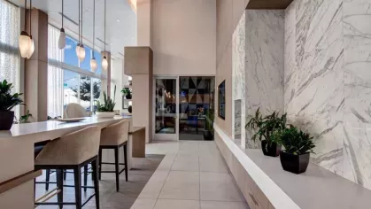 Sophisticated interior design with marble accent walls and pendant lighting in The Pacific Luxury Apartments' communal space.