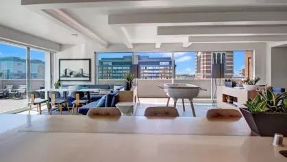 Rooftop lounge with open seating, a foosball table, and panoramic city views at The Pacific Luxury Apartments.