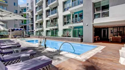 Relaxing poolside ambiance with comfortable seating and stylish cabanas at The Pacific Luxury Apartments.