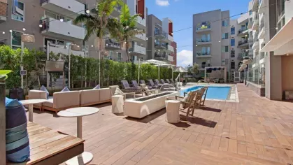 Inviting outdoor lounge with modern furnishings and pool access at The Pacific Luxury Apartments.