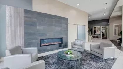 Elegant lobby seating area with a minimalist electric fireplace and neutral tones.