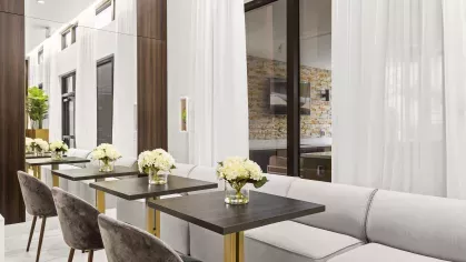 Luxurious meeting and lounge area with dark wood furnishings, polished surfaces, and modern lighting.