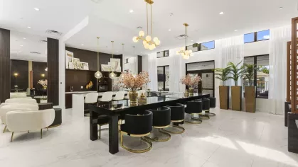 Luxurious meeting and lounge area with dark wood furnishings, polished surfaces, and modern lighting.