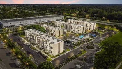 The exterior of a multi-story apartment building with private balconies and landscaped surroundings, representing stylish and spacious living at Pine Ridge Luxury Apartments.