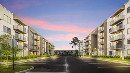 The exterior of a multi-story apartment building with private balconies and landscaped surroundings, representing stylish and spacious living at Pine Ridge Luxury Apartments.