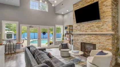 The resident lounge at Oak Enclave features a sleek stone fireplace, plush seating, and an open-concept design, creating a sophisticated and cozy space.