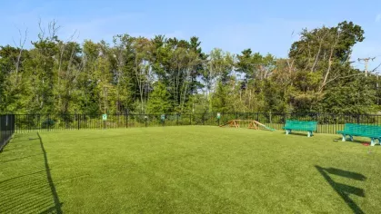 The on-site dog park at Oak Enclave Luxury Apartments provides a spacious, fenced-in area with agility equipment and seating, ensuring a fun and secure environment for pets and owners.