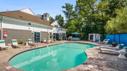 The luxurious pool area at Oak Enclave Luxury Apartments offers a sparkling resort-style pool, comfortable lounge seating, and shaded cabanas for ultimate relaxation.
