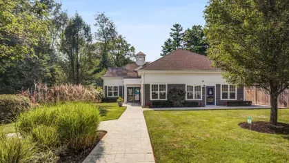 The leasing office at Oak Enclave Luxury Apartments is surrounded by lush landscaping, offering a warm and inviting entrance to the community.