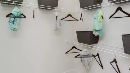 Spacious walk-in closet with wire shelving, storage bins, and ample hanging space at Riverworks Luxury Apartments.