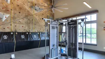 "Well-equipped fitness center at Riverworks Luxury Apartments with advanced training equipment and a large rock climbing wall."