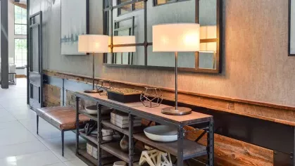 Cozy and stylish seating nook in the hallway of Riverworks Luxury Apartments with warm lighting and rustic decor.