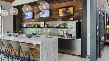 Contemporary coffee bar and kitchen space at Riverworks featuring a modern island with barstool seating.