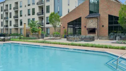 Sparkling outdoor pool at Riverworks Luxury Apartments surrounded by modern architecture and lush landscaping.