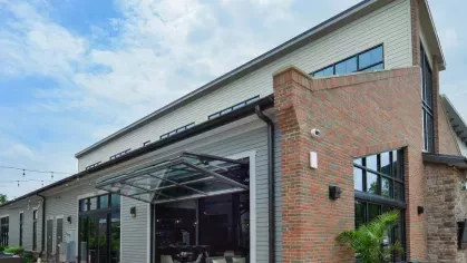 Image of the Riverworks Luxury Apartments' modern outdoor patio area with stylish seating and large glass doors that open to the interior lounge.