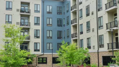 Beautifully landscaped courtyard at Riverworks Luxury Apartments with walking paths, green spaces, and vibrant flower beds.