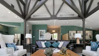 A stylish clubhouse lounge with high ceilings, exposed beams, elegant seating, and contemporary decor.
