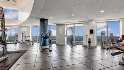 A state-of-the-art fitness center with cardio machines, strength training equipment, and floor-to-ceiling windows showcasing stunning skyline views, enhancing your workout experience.