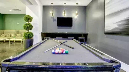 Stylish billiards room with a pool table, comfortable seating, and contemporary decor for leisure activities.