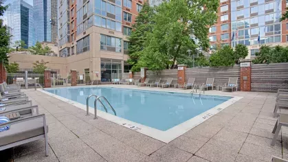 A well-maintained pool surrounded by contemporary architecture and lush landscaping for residents to relax.