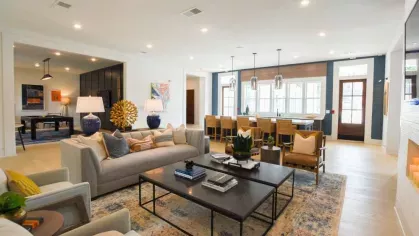 An inviting lounge with a mix of modern and classic decor, complete with a cozy seating area, a communal dining table, and large windows for natural light.