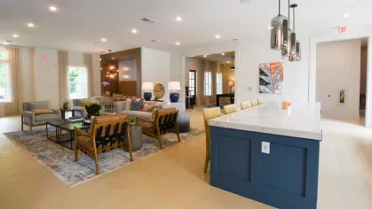 A chic resident lounge with a spacious kitchen island, stylish pendant lighting, and an inviting open-concept layout, perfect for social gatherings.