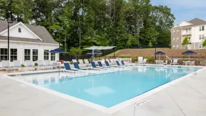 A refreshing swimming pool with in-water lounge chairs and a spacious deck, providing residents with a resort-inspired outdoor experience.
