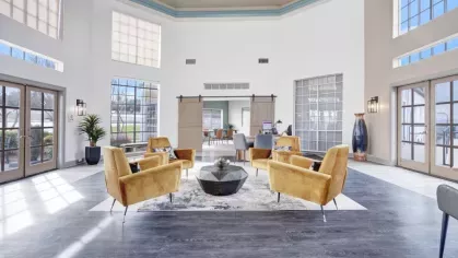 Bright and spacious lobby area with modern yellow seating and large windows.