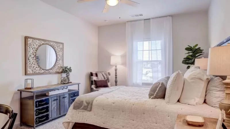Beautifully decorated bedroom at The Emerson at Forney with soft, neutral tones and ample natural light for a serene retreat.