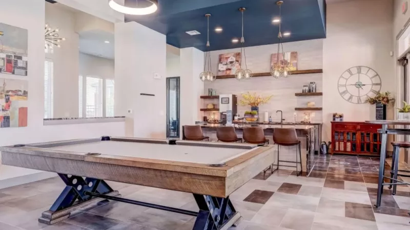 Chic clubhouse featuring a modern pool table, stylish seating, and a spacious entertainment area at The Emerson at Forney Luxury Apartments.