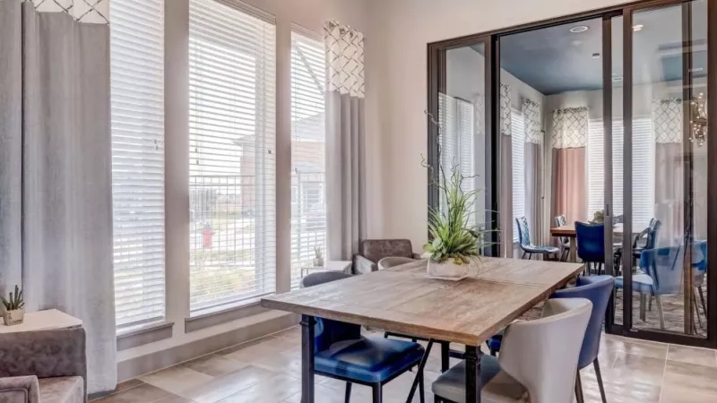 Bright and modern dining area at The Emerson at Forney Luxury Apartments, featuring natural light, stylish furnishings, and a private meeting room.