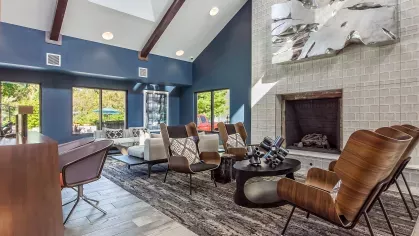 Contemporary lounge area with modern decor, a gray sectional sofa, and a unique red and white accent wall.