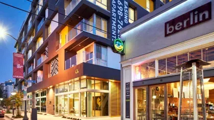 "The Linden Luxury Apartments exterior at night, highlighting floor-to-ceiling windows and vibrant urban surroundings"