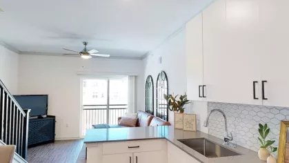 Chic kitchen design featuring a large island, built-in microwave, and contemporary light fixtures at The Prospector Modern Luxury Apartments.