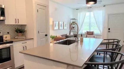 Sleek and modern kitchen with premium appliances, white cabinets, and an open layout perfect for entertaining at The Prospector Modern Luxury Apartments.