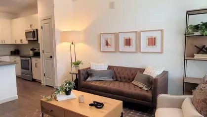 Bright and modern living area at The Prospector Modern Luxury Apartments, showcasing an open concept with sleek white cabinetry and a cozy lounge space.