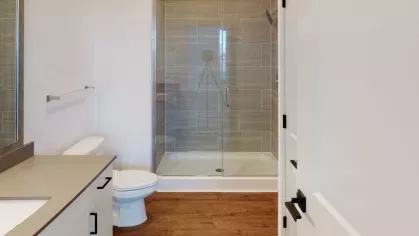 Contemporary bathroom with a glass-enclosed shower, sleek tile work, and modern vanity with ample storage space.