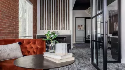 Intimate seating area featuring a vibrant orange sofa, modern decor, and a cozy atmosphere perfect for relaxation or meetings.