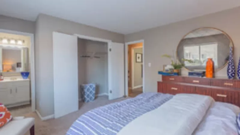 Cozy bedroom with a large mirror, plush bedding, and an ensuite bathroom.