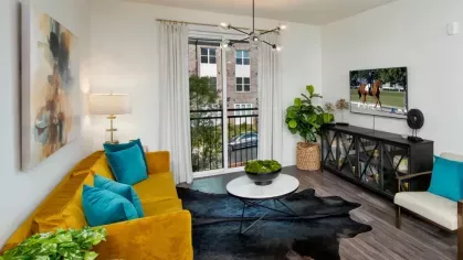 Cozy living space featuring a yellow sofa, vibrant decor, and a view of the balcony.