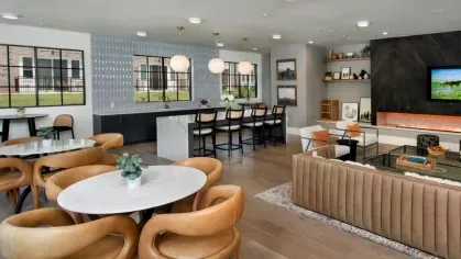 A vibrant community lounge with cozy seating, a large TV, and a mix of dining and conversation areas.