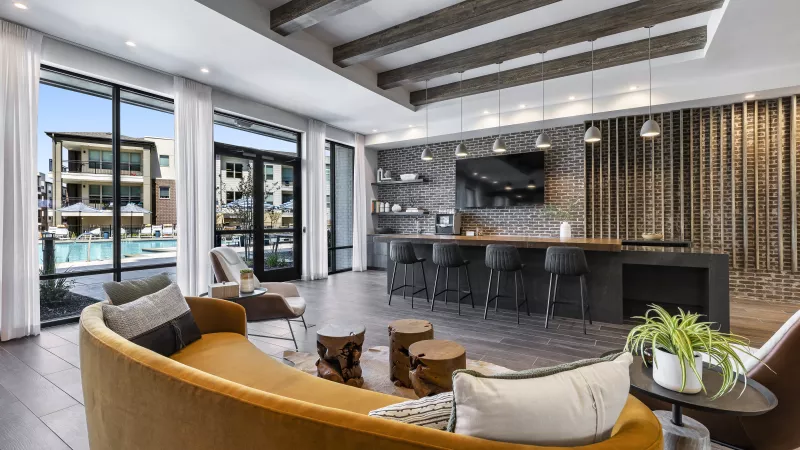 The Warner Apartments’ co-working lounge, designed with exposed brick walls, stylish workspace seating, and hanging pendant lights, creating a perfect balance of productivity and comfort.