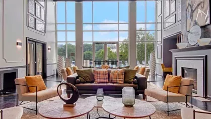A luxurious community lounge with high ceilings, expansive windows, and contemporary seating for resident gatherings.