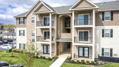An exterior view of Victoria Manor apartment buildings, showcasing private balconies and well-maintained landscaping.